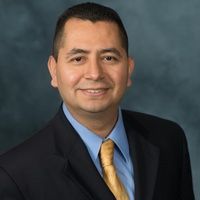A man in a suit and tie is smiling for the camera.