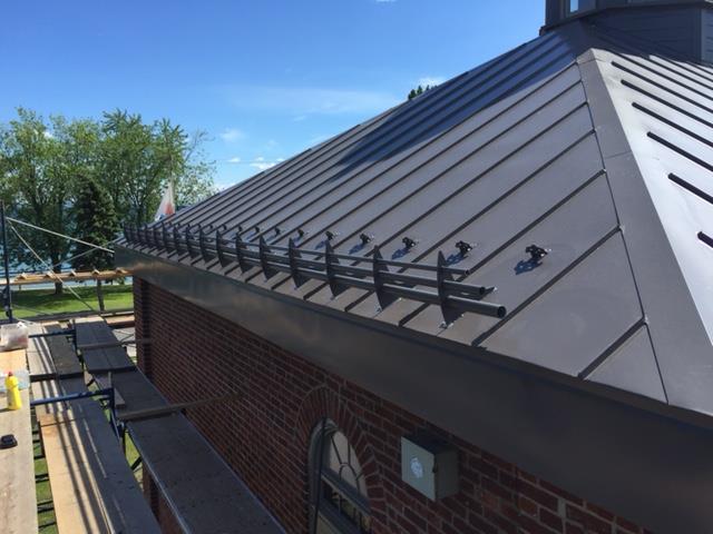 Un bâtiment en brique avec un toit en métal et des gouttières