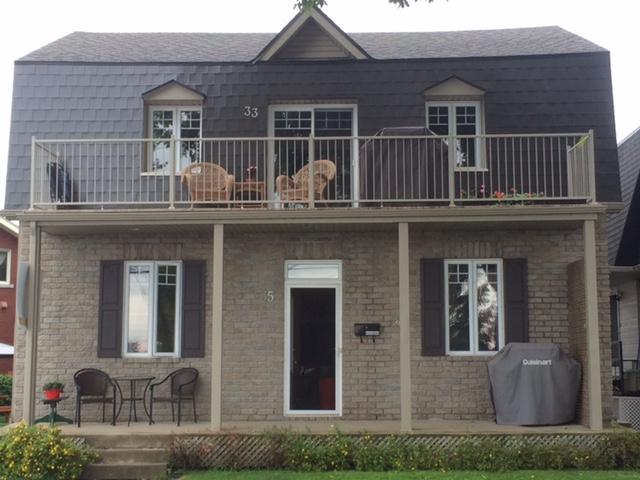 A brick house with a balcony and the number 32 on the roof