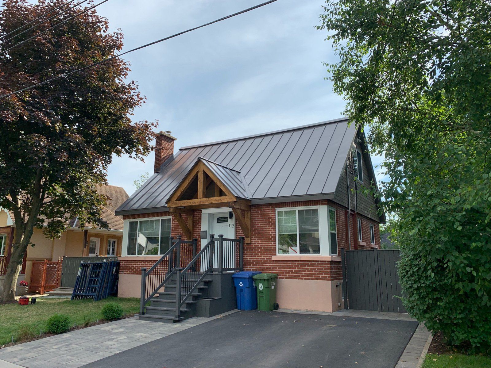 Une petite maison en brique avec un toit et des escaliers en métal