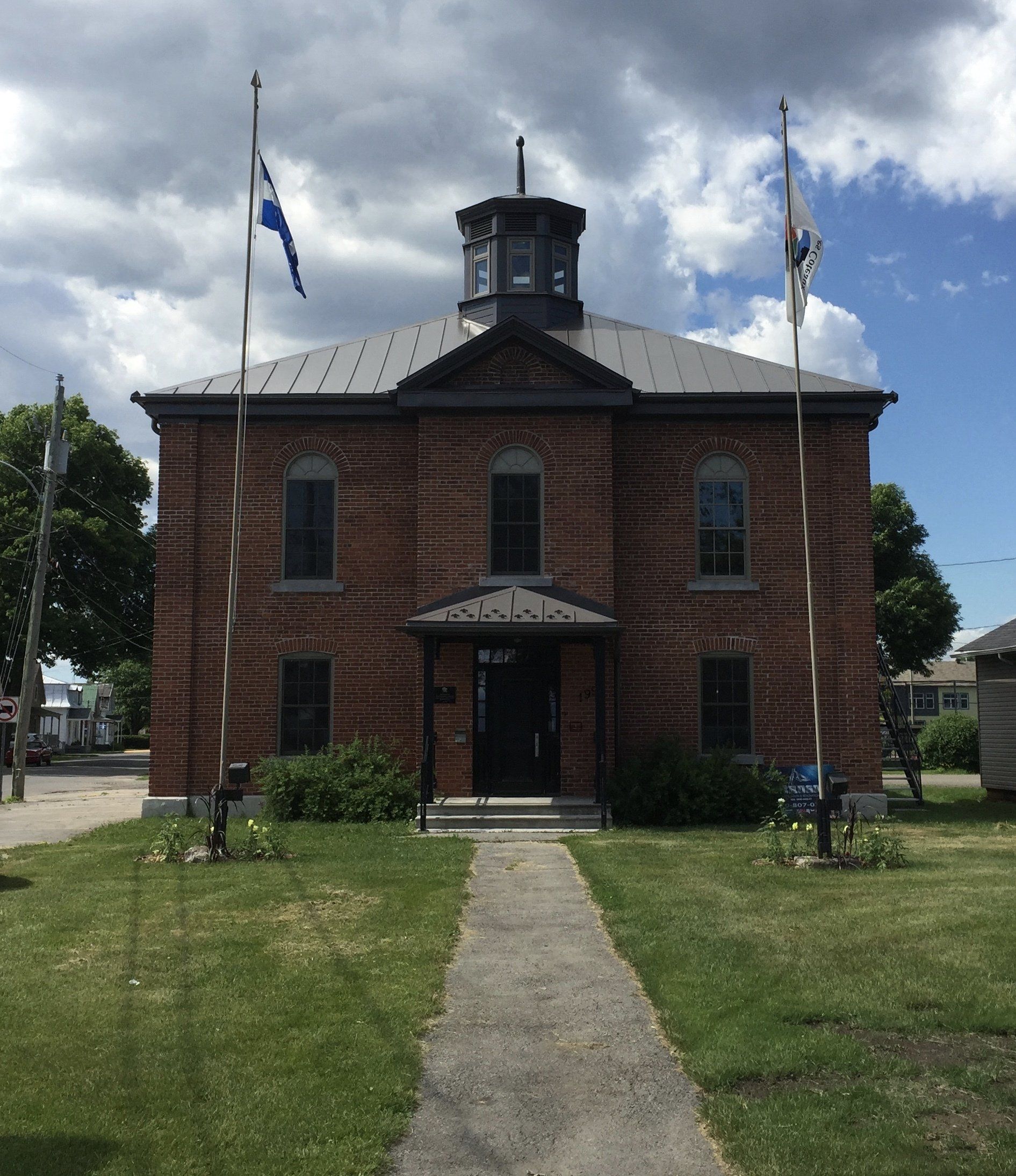 Un grand bâtiment en brique avec des drapeaux devant lui
