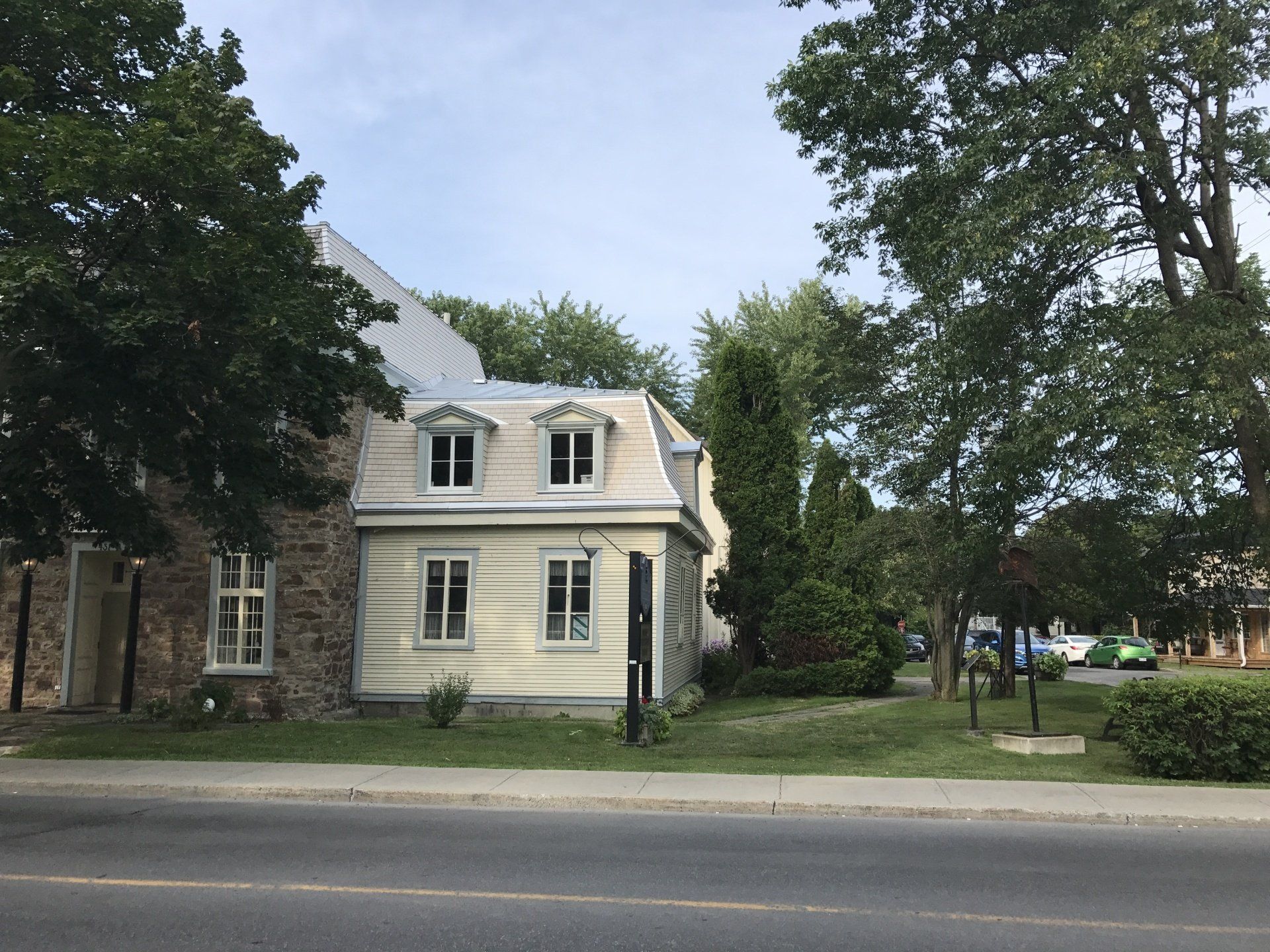 Une maison avec beaucoup de fenêtres et d'arbres devant