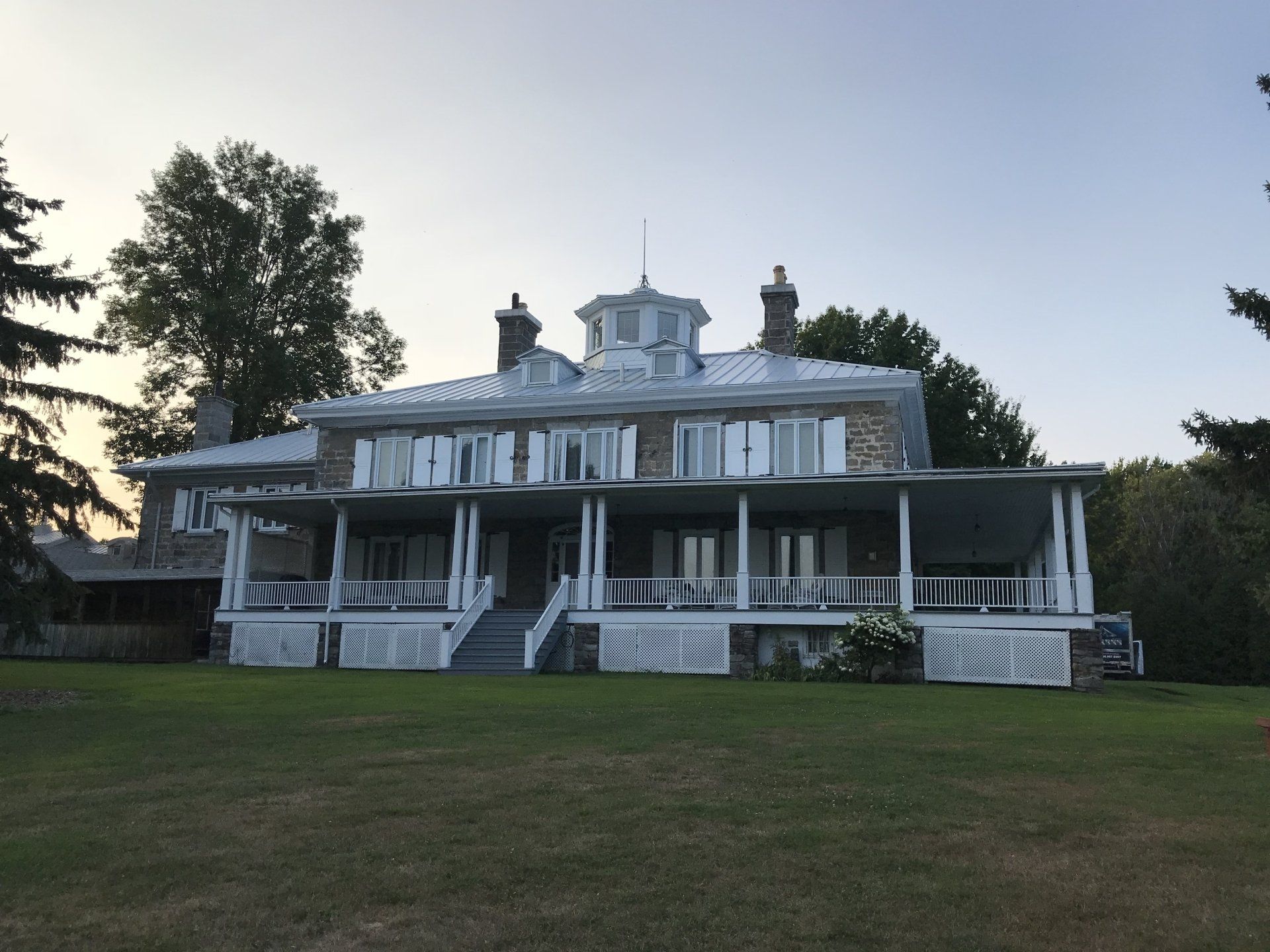 Une grande maison avec un grand porche et des escaliers