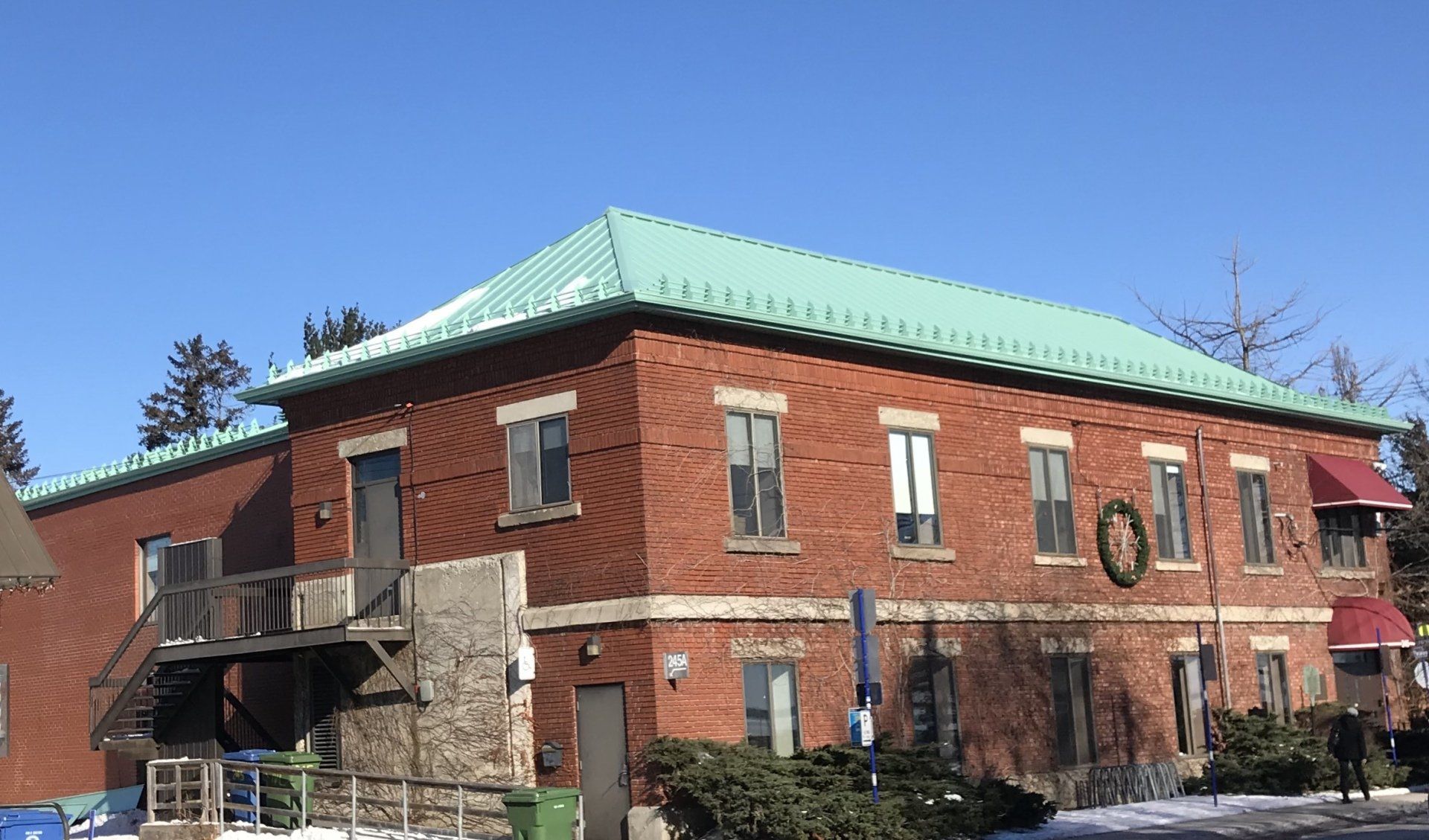 Un grand bâtiment en brique avec un toit vert