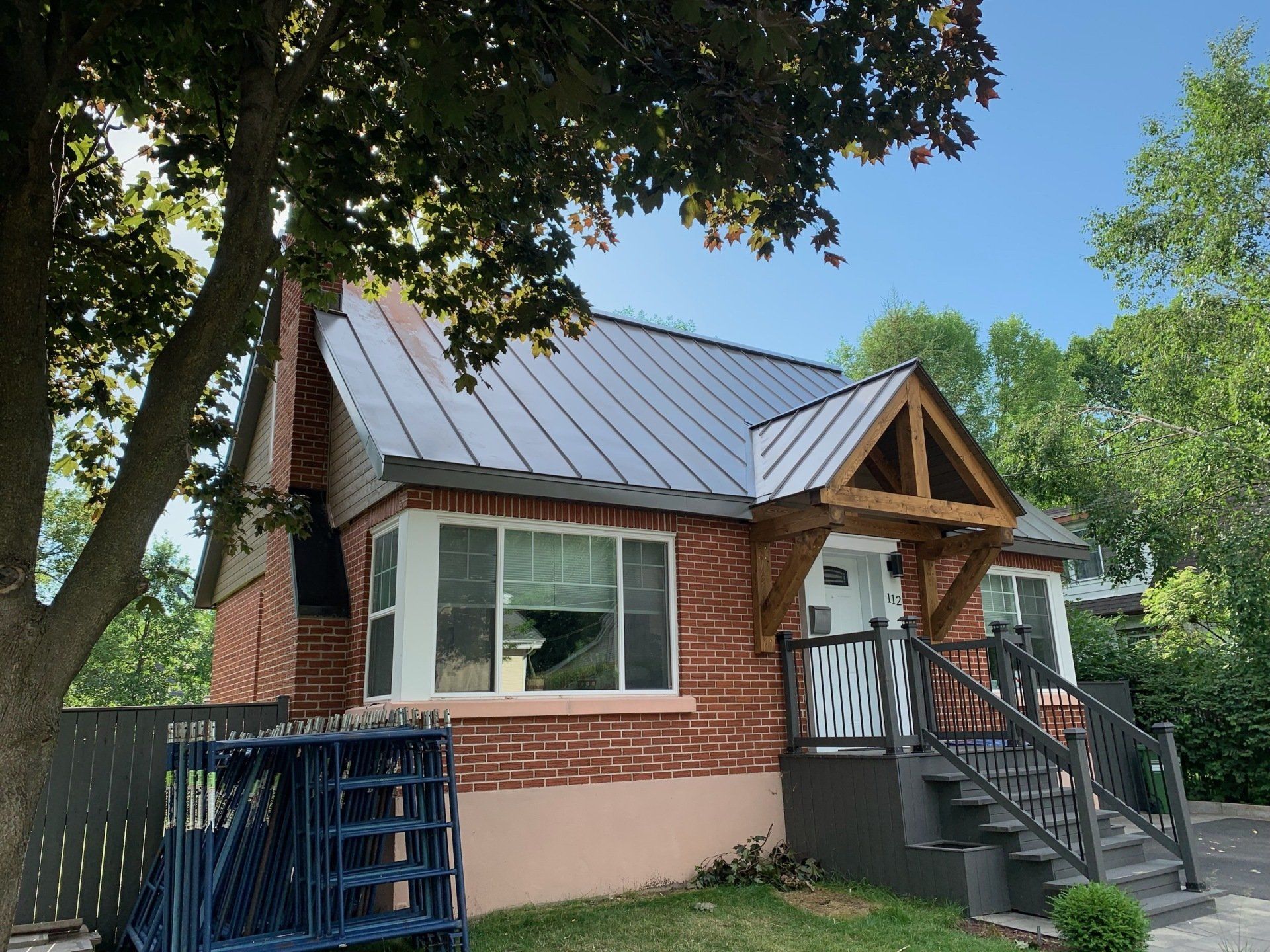 Une petite maison en brique avec un toit et des escaliers en métal.