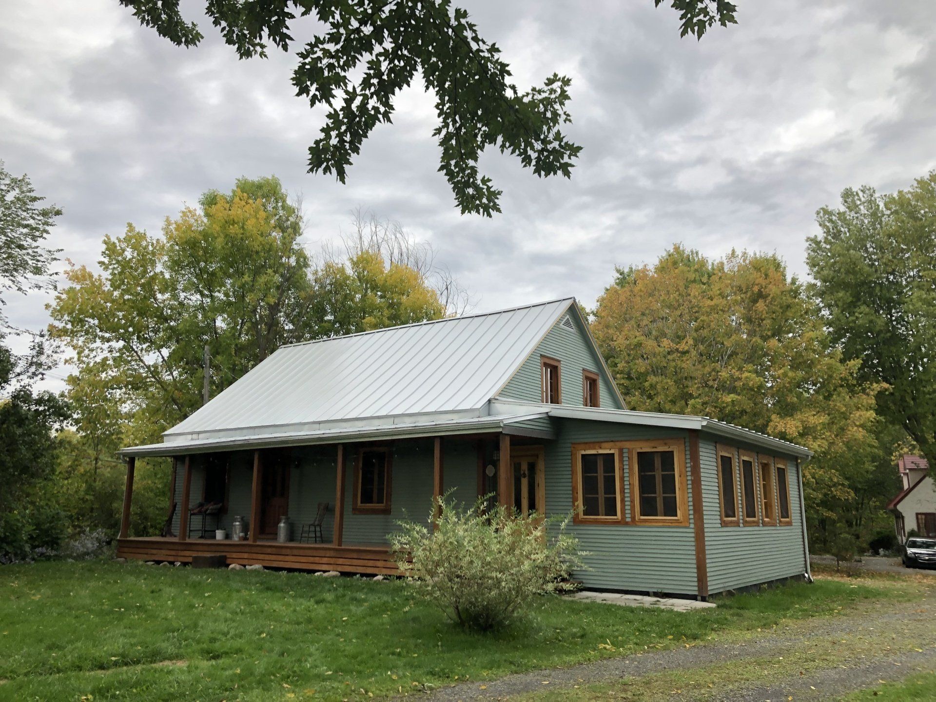 Une maison avec un porche et un toit en métal