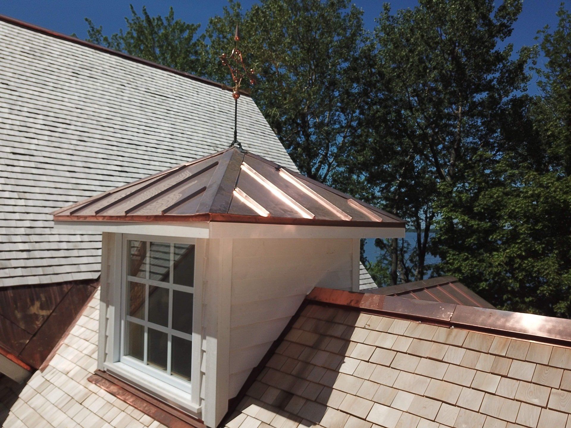 Une maison blanche avec un toit en cuivre et une fenêtre