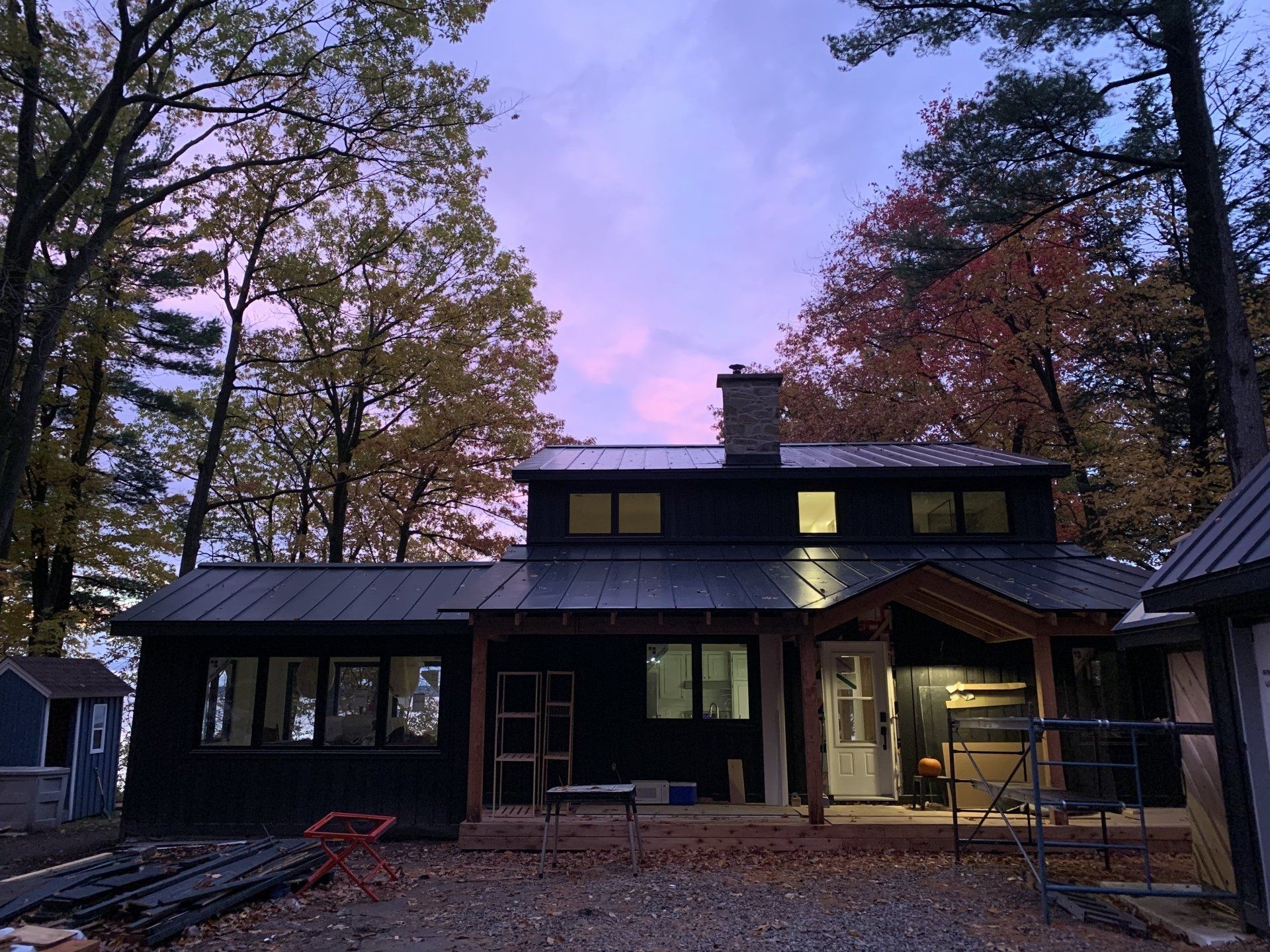 Une maison noire avec un ciel violet en arrière-plan