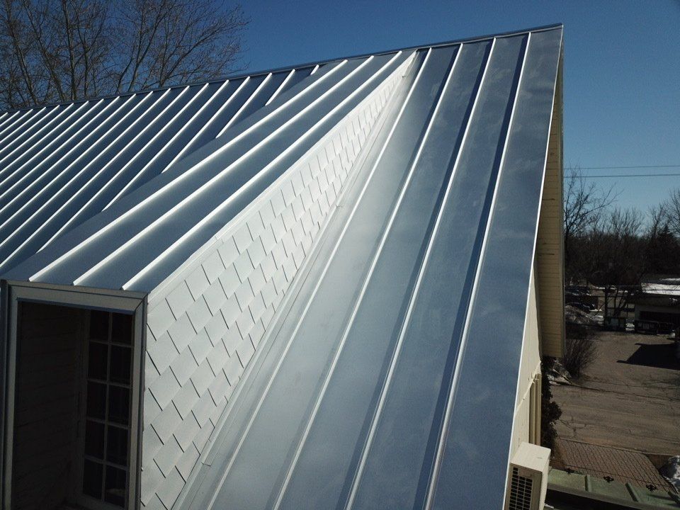 Une maison avec un toit en métal et des boiseries blanches