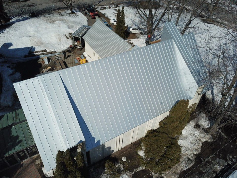 Une vue aérienne d'un bâtiment blanc avec un toit en métal
