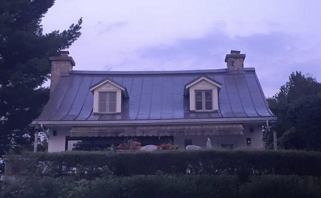 A house with a purple sky in the background