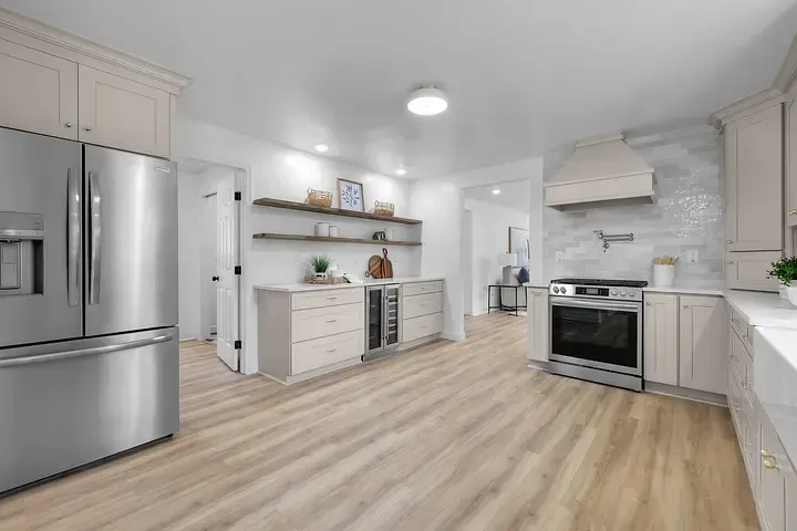 A kitchen with stainless steel appliances and wooden floors.