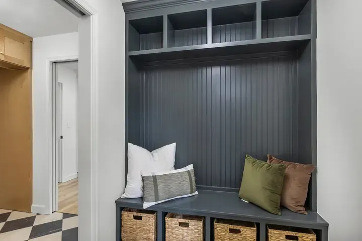 A mud room with a bench and baskets in it.