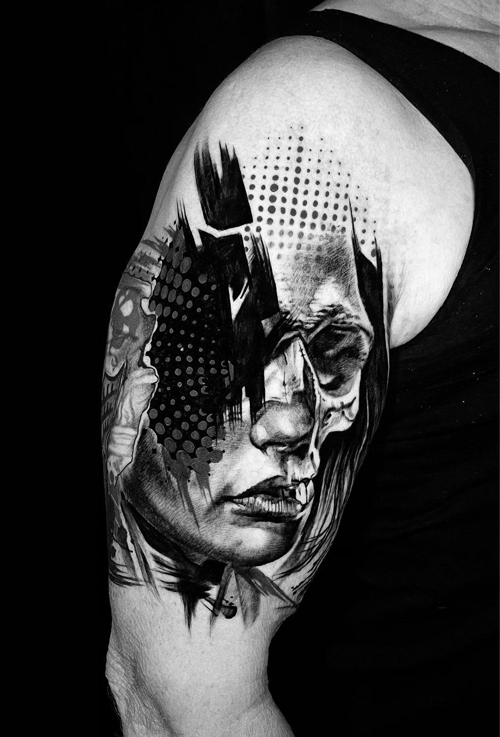 Schwarz-weißes Blumentattoo auf dem Arm einer Person, neben einem Button-Down-Hemd.