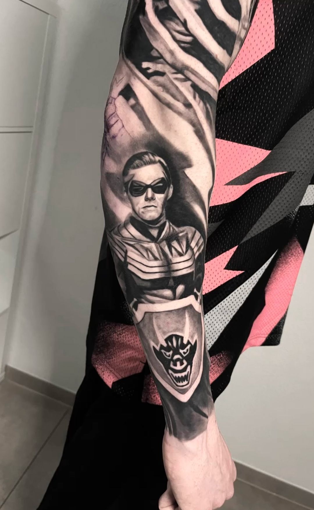 A man with a tattoo on his arm of a man wearing sunglasses.