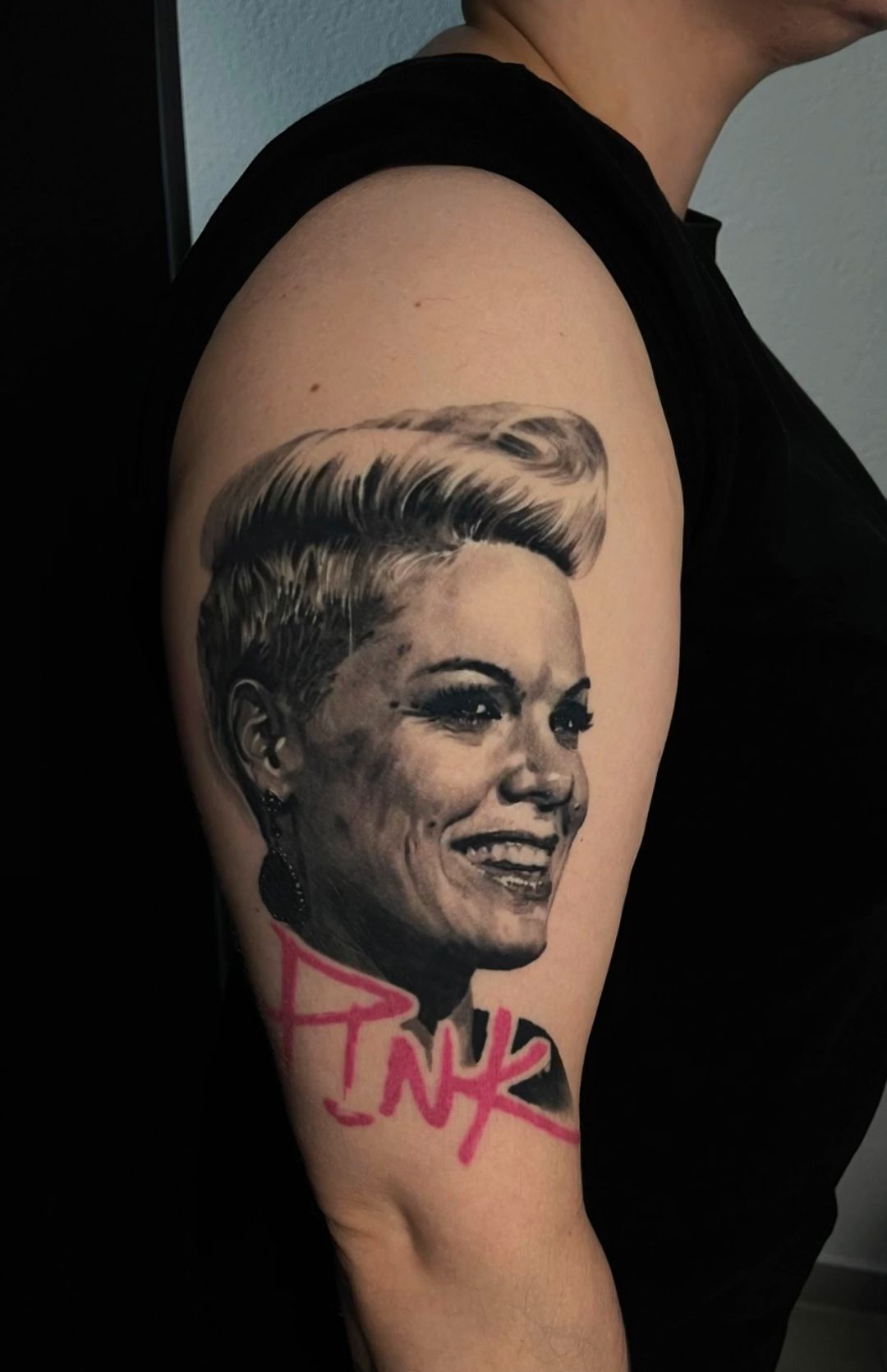 A woman has a tattoo of pink on her arm