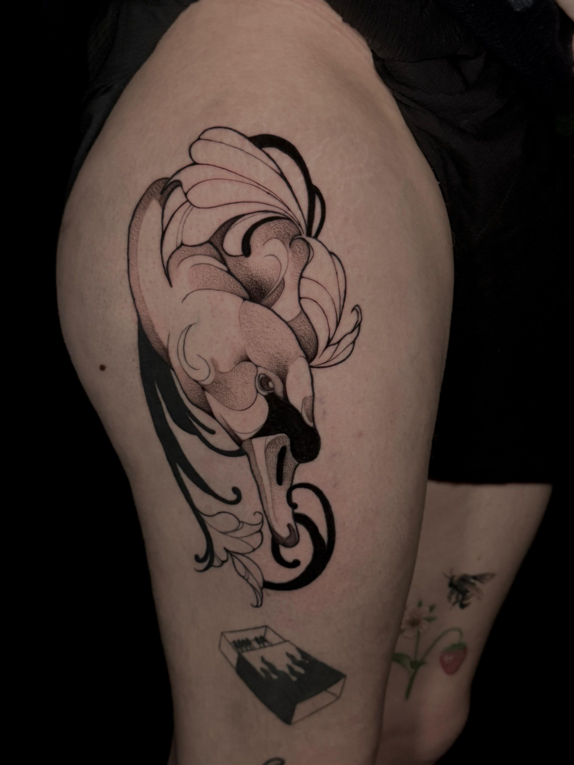 Eine Frau hat ein Schwanentattoo auf ihrem Oberschenkel