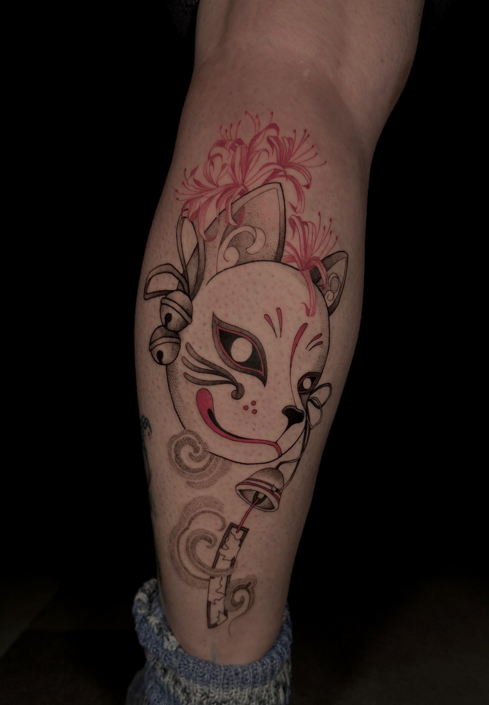 Eine Person hat eine Katzentätowierung auf ihrem Bein.