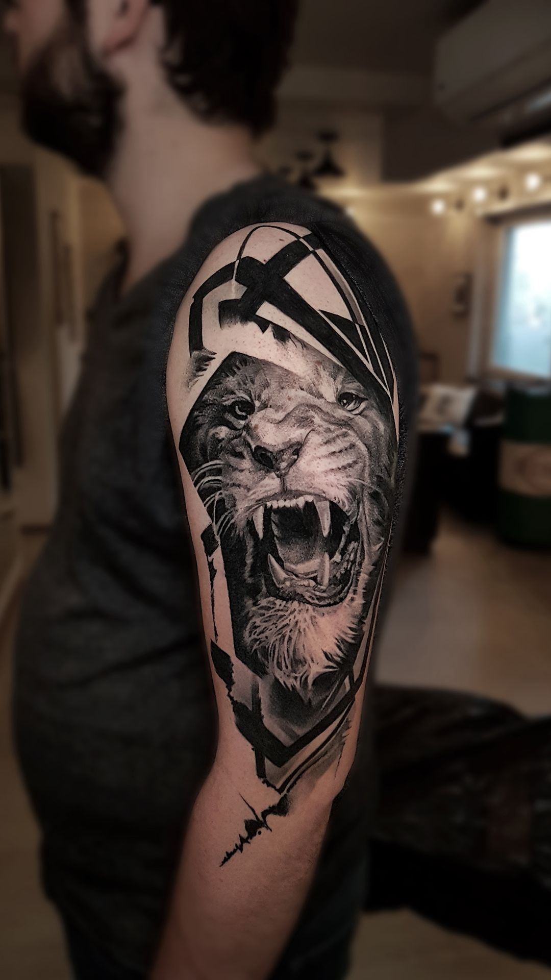 A man has a tattoo of a lion on his arm.
