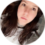 A woman with long brown hair is taking a selfie in a circle.