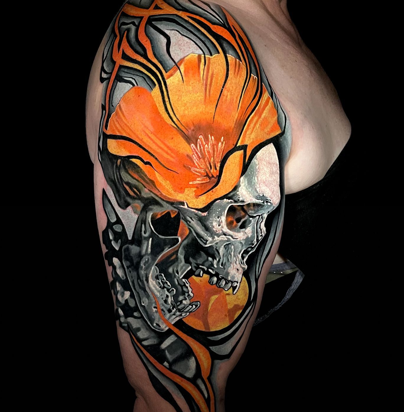 A woman has a tattoo of a skull and a flower on her arm.