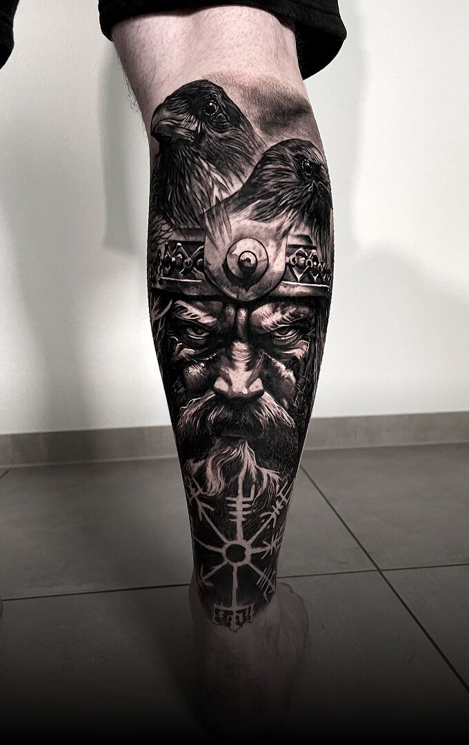 A black and white tattoo on a person 's leg.