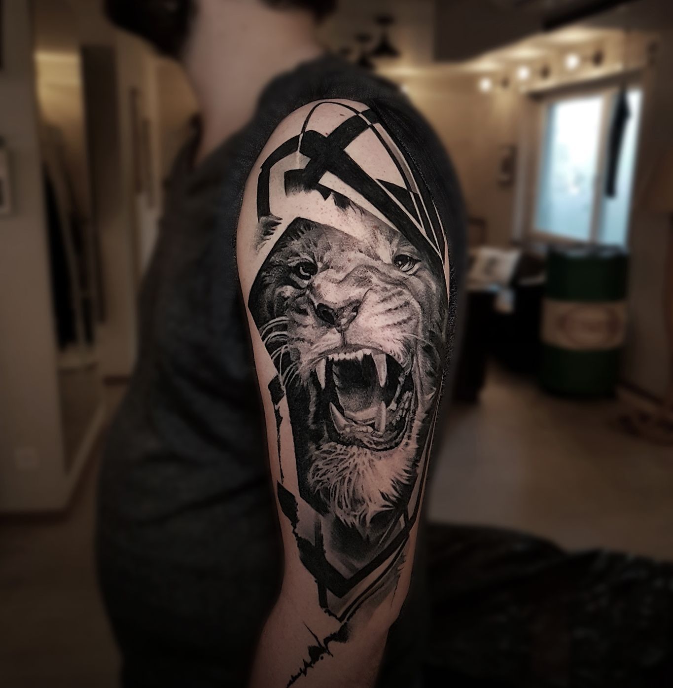 A man has a tattoo of a lion on his arm.