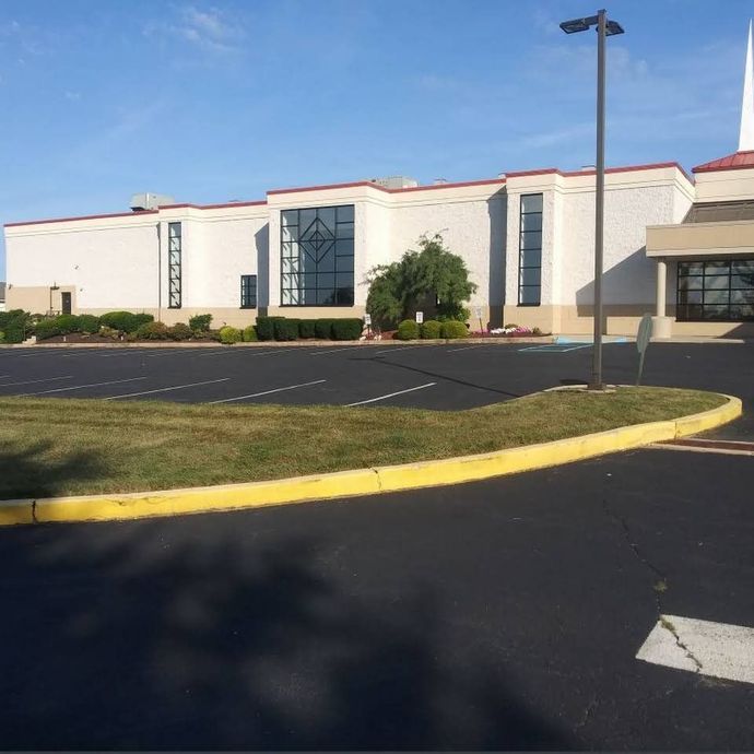 A large white building with a yellow curb in front of it