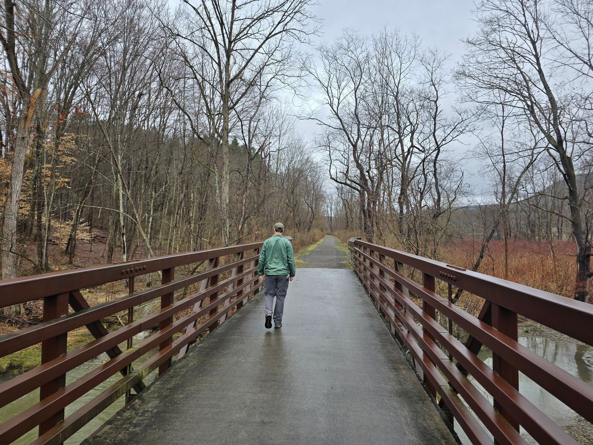 Person walking across a bridge on the Cuba Greenway Trail