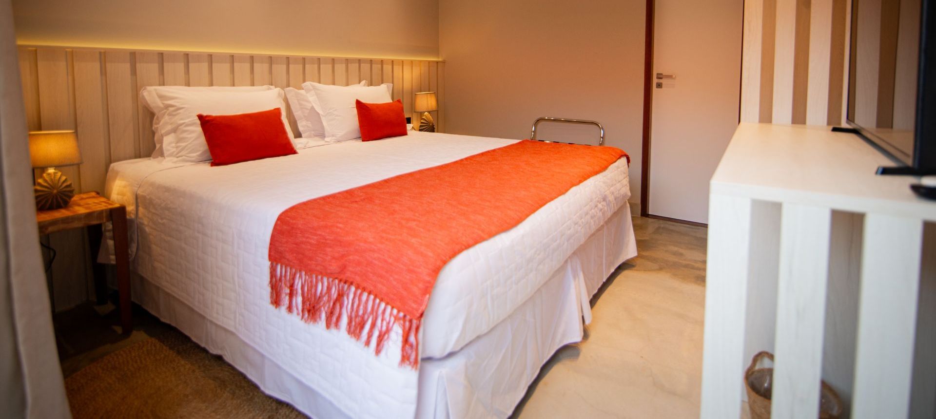 Um quarto de hotel com uma cama king size e uma TV de tela plana Pousada Xica