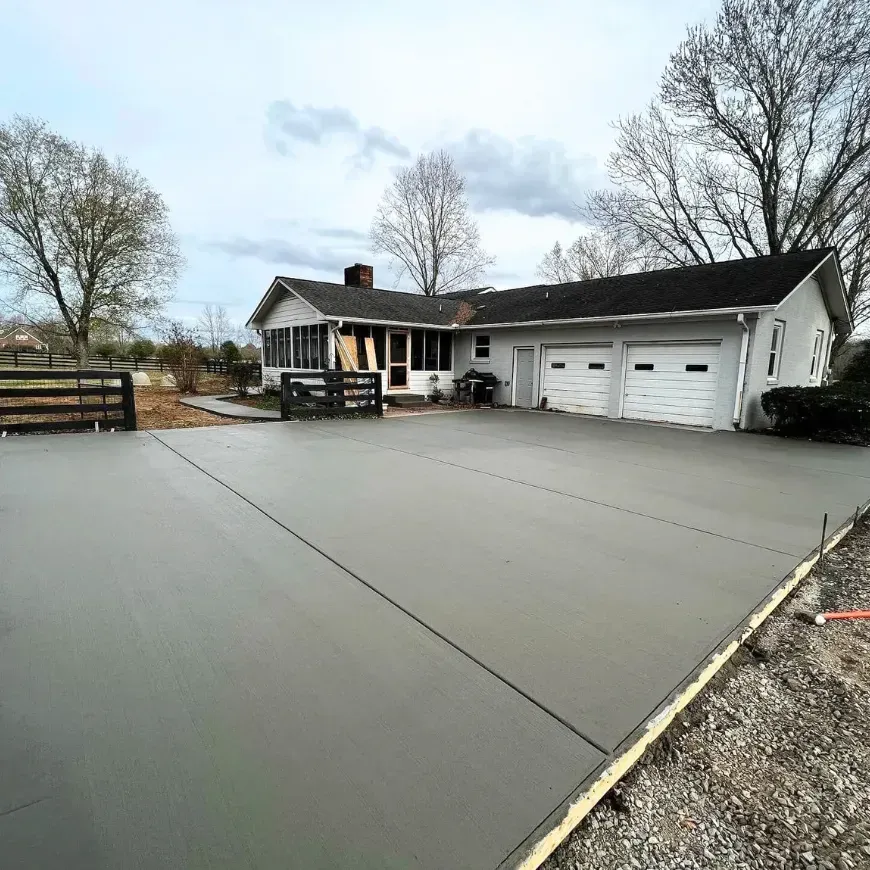 A concrete driveway is being built in front of a house.