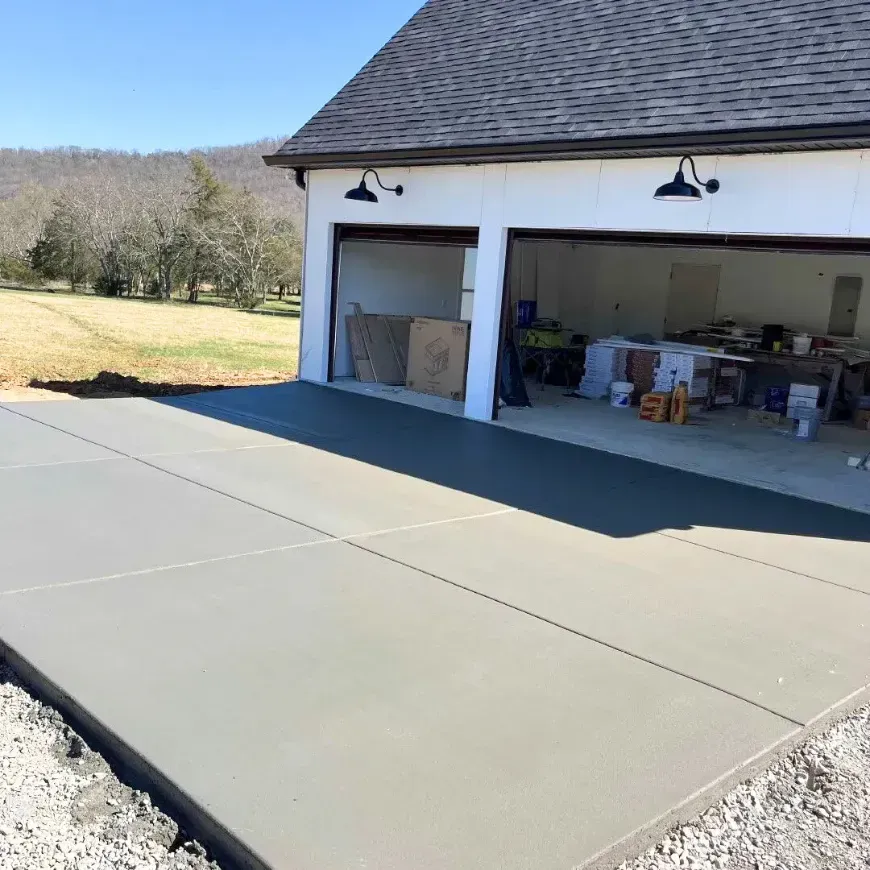 An empty barn with a concrete floor and a wooden roof. Project done by Raise the Bar Construction