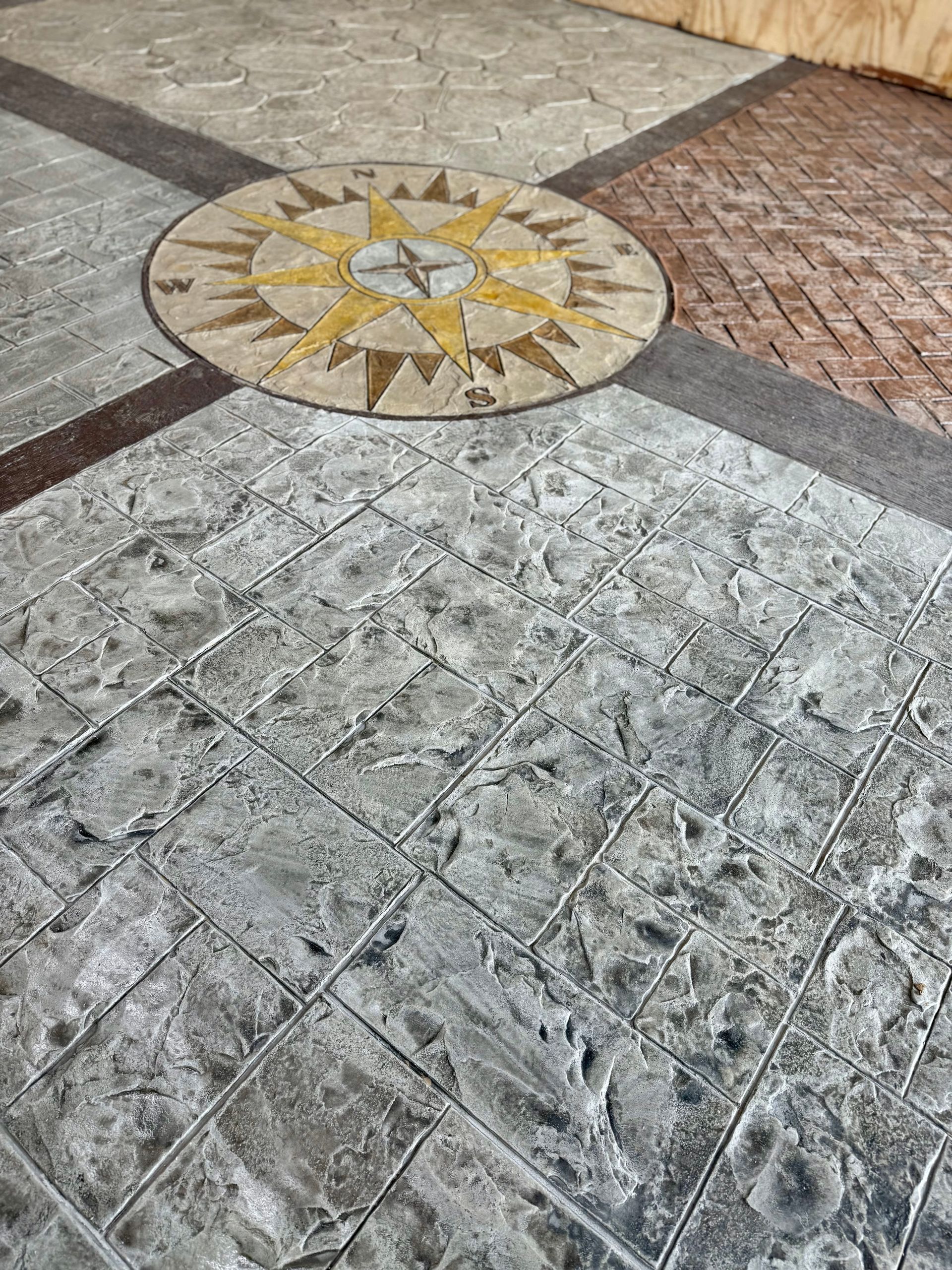 A close up of a concrete floor with a compass in the middle.