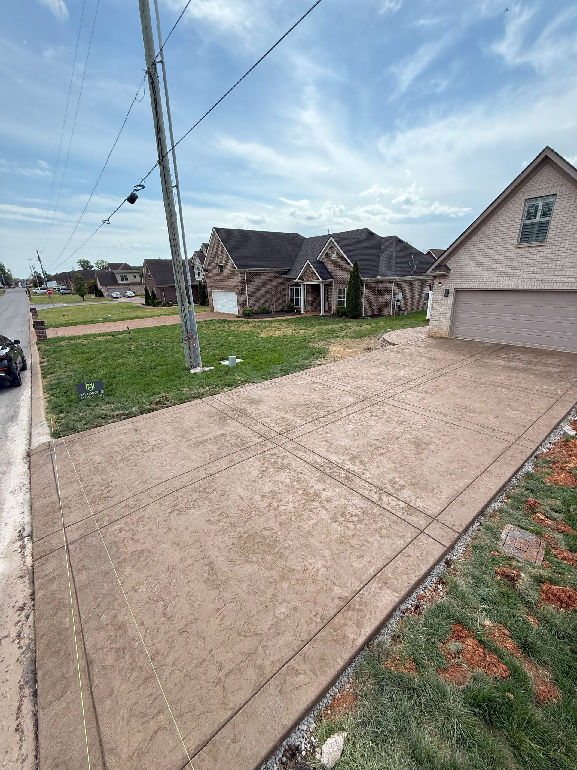A car is parked on the side of the road in front of a house.
