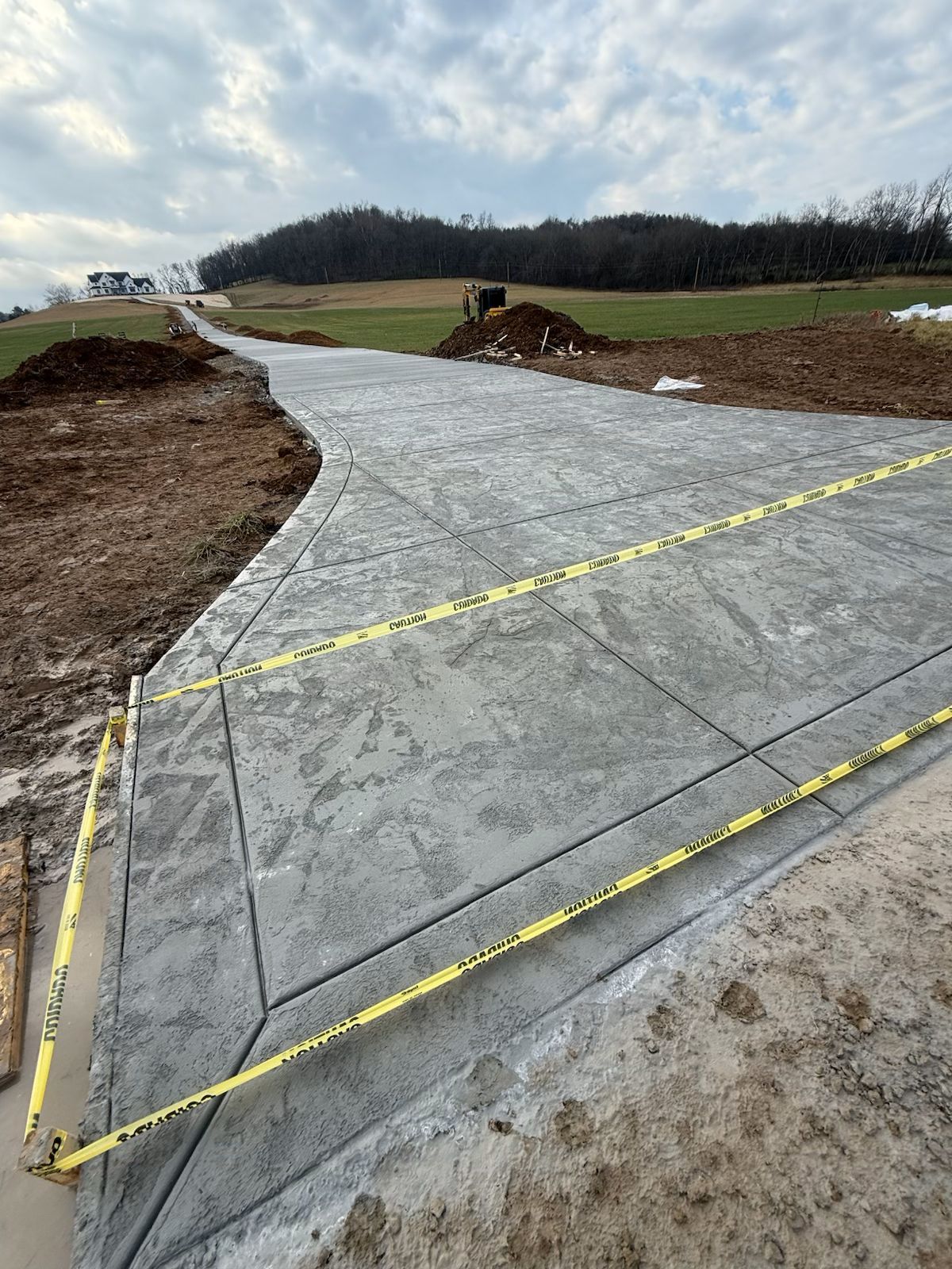A concrete driveway is being built in a field.