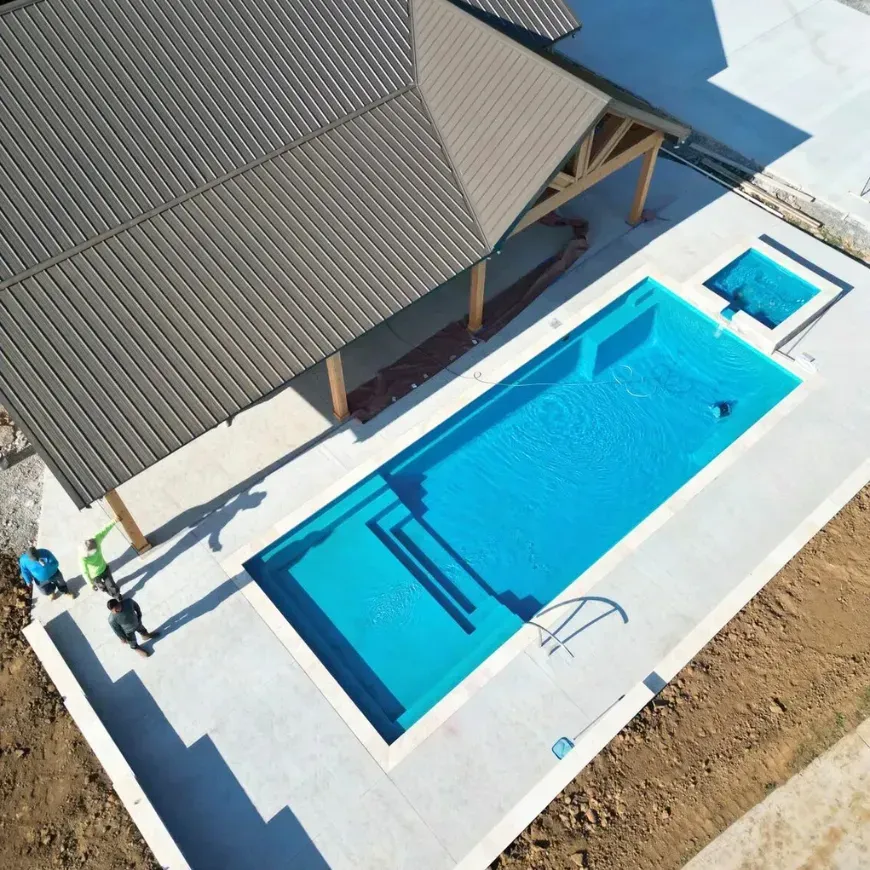 An aerial view of a large swimming pool under a pavilion