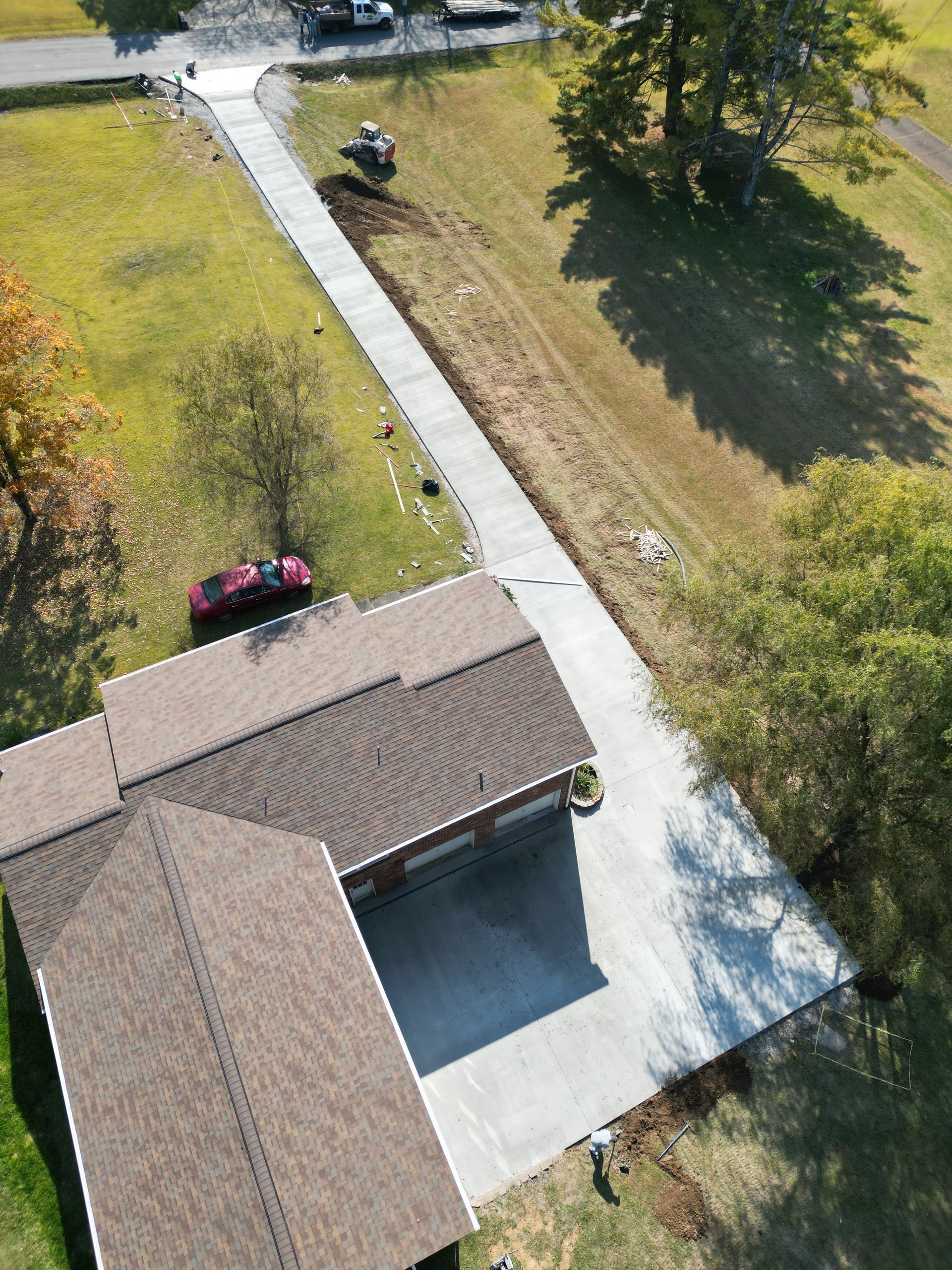 An aerial view of a house with a car parked in the driveway.