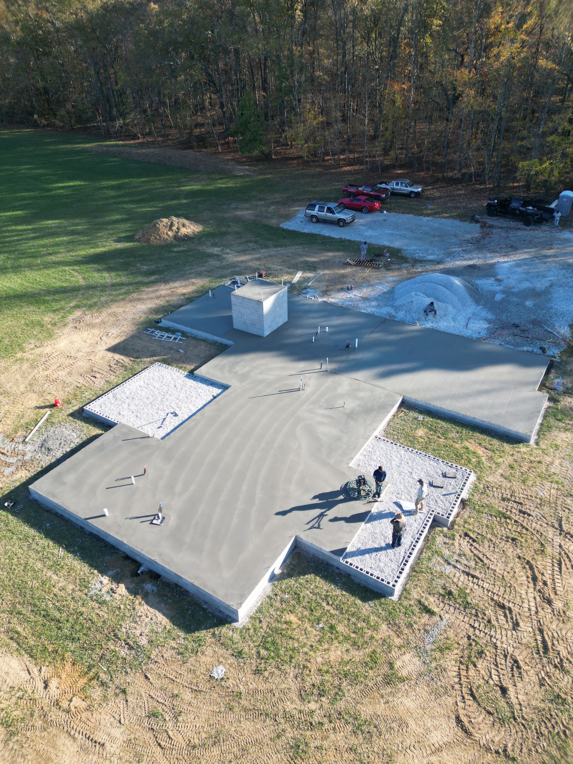 An aerial view of a concrete foundation being built in a field.