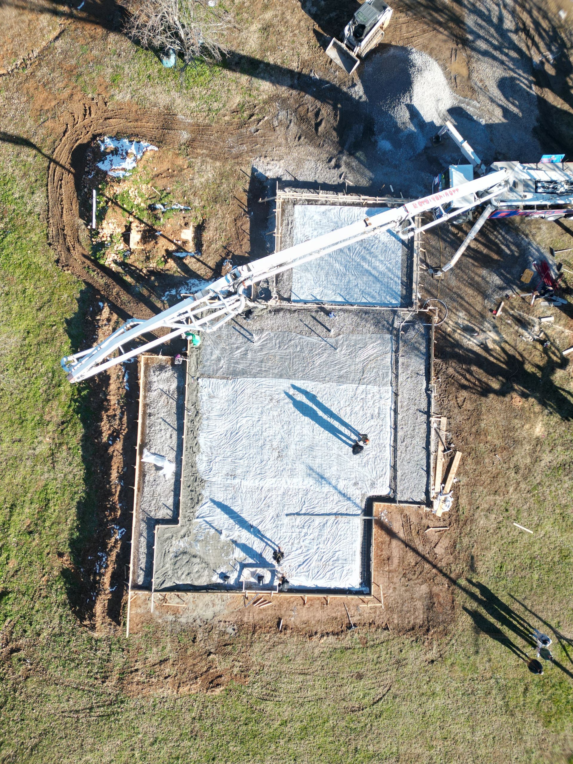 An aerial view of a construction site with a concrete pump.
