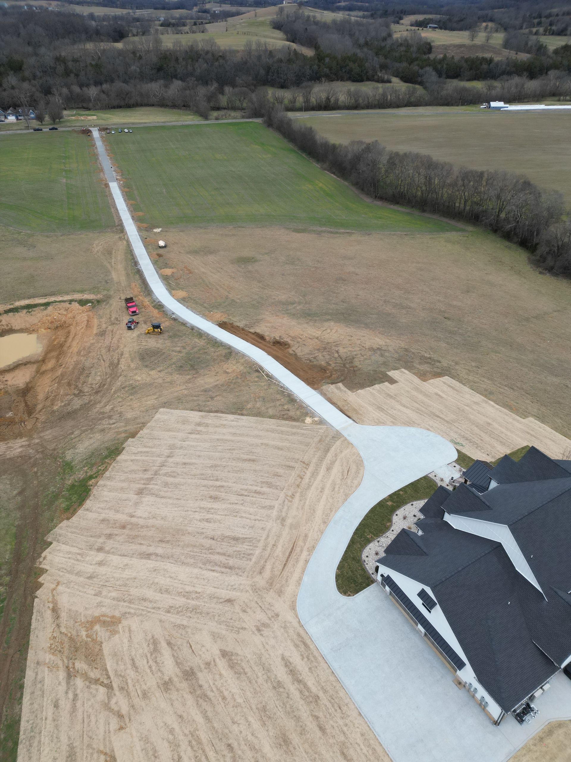 An aerial view of a house in the middle of a field