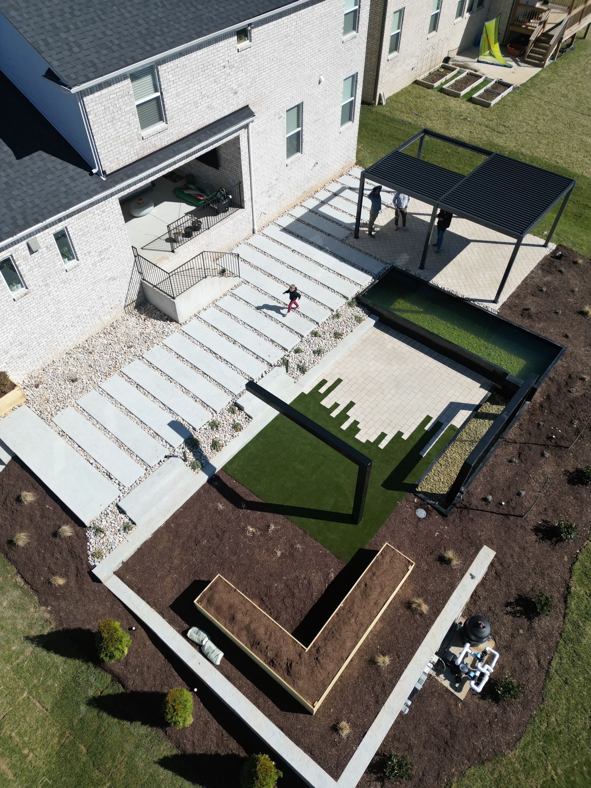 An aerial view of a backyard with a house in the background