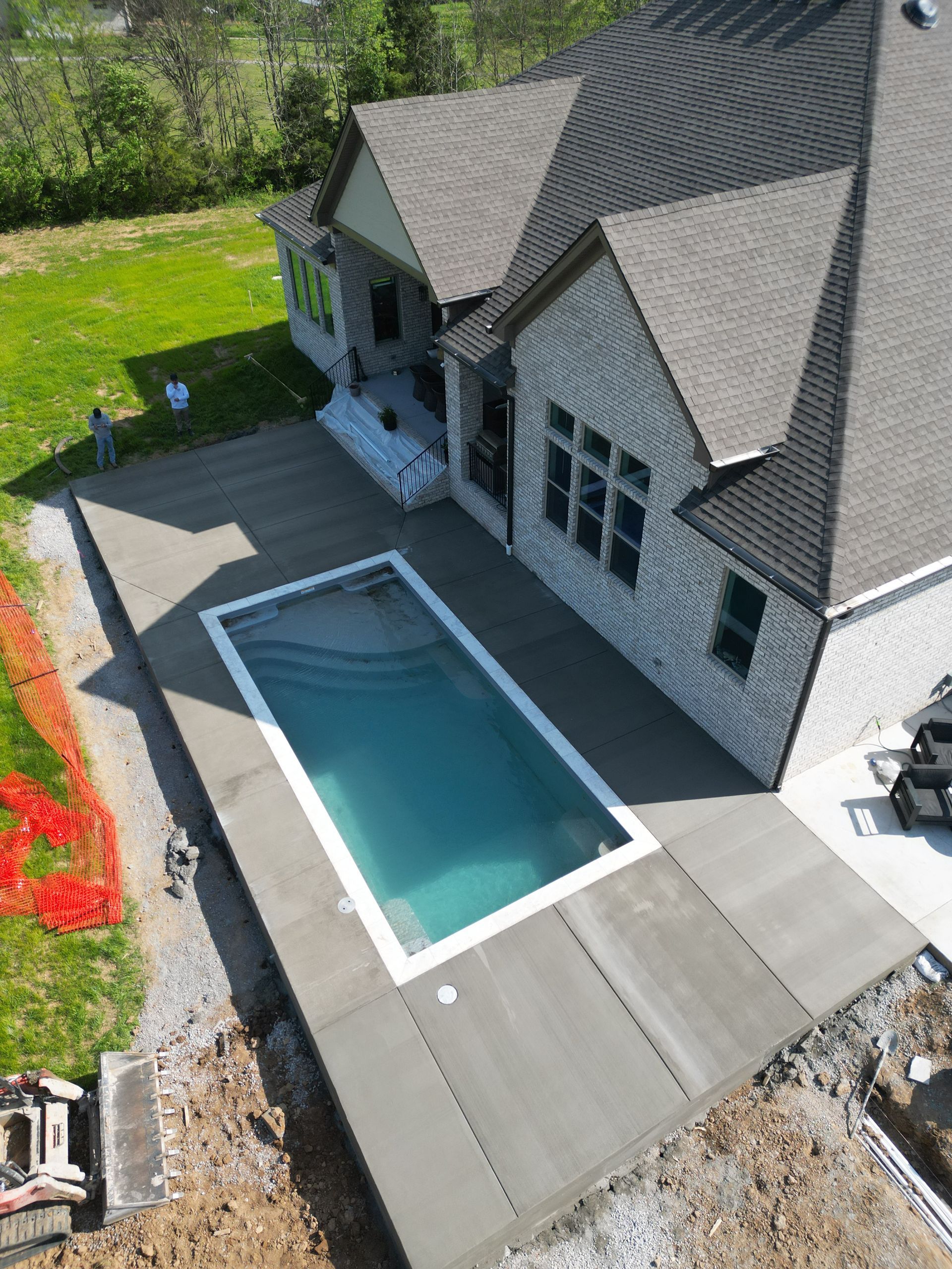 An aerial view of a house with a large swimming pool in the backyard.