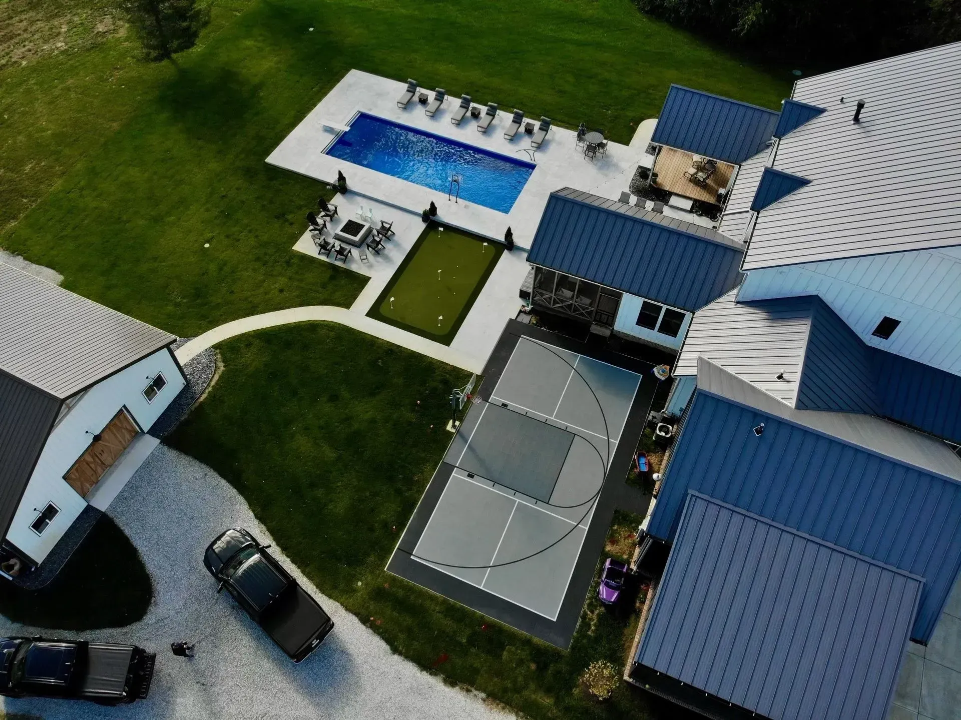 An aerial view of a house with a basketball court and a pool