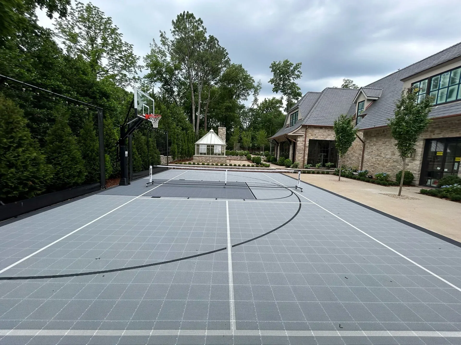 A basketball court is being built in front of a house.