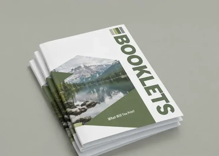 Stack of white booklets with a mountain-and-lake cover and bold green “BOOKLETS” text. Print and design at Total Creative, Auckland NZ