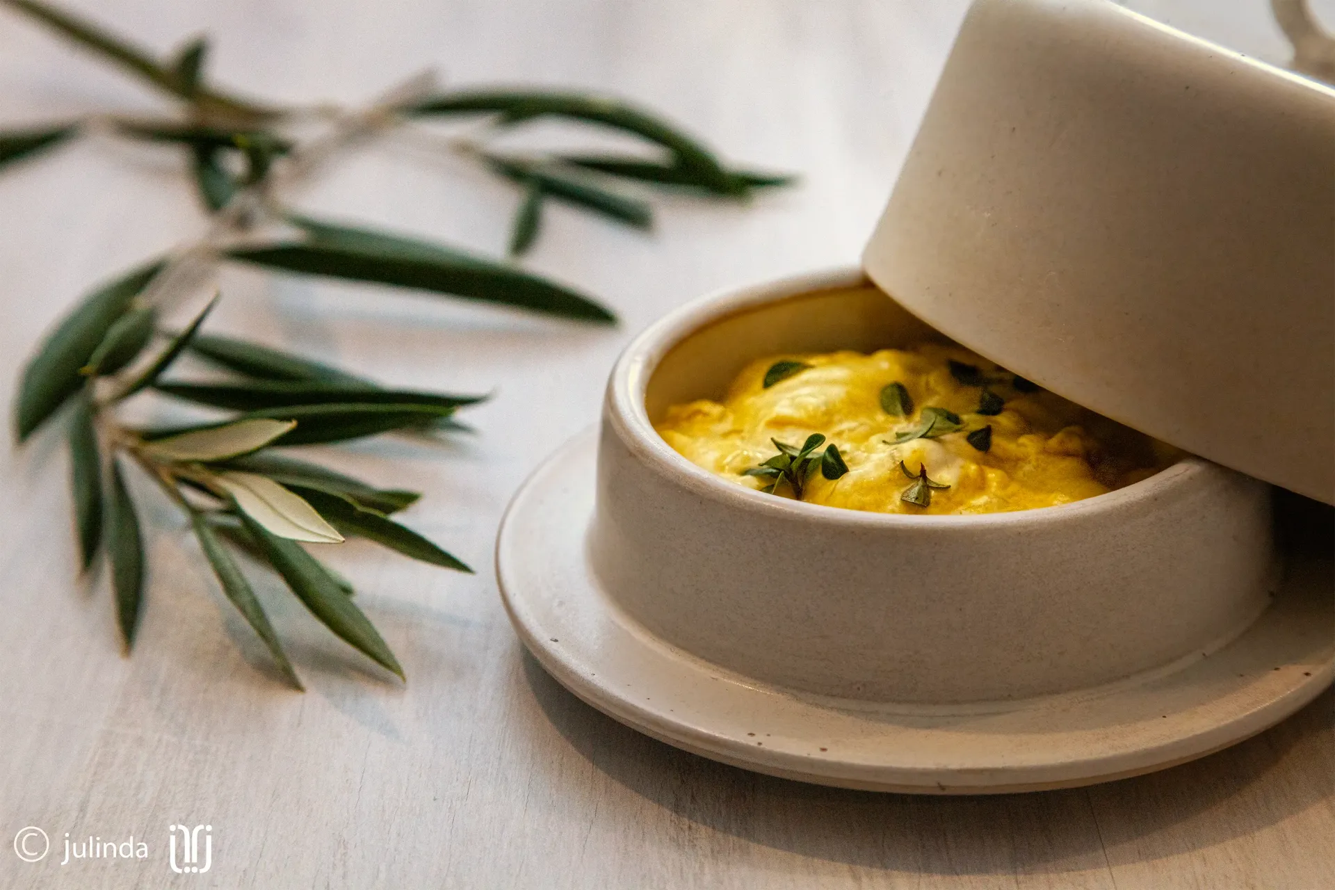 Butter dish container - organic coconut sauce food photography with green herb garnish on a table, with olive branches nearby. Follow Discover Flavour and Total Creative for the recipe