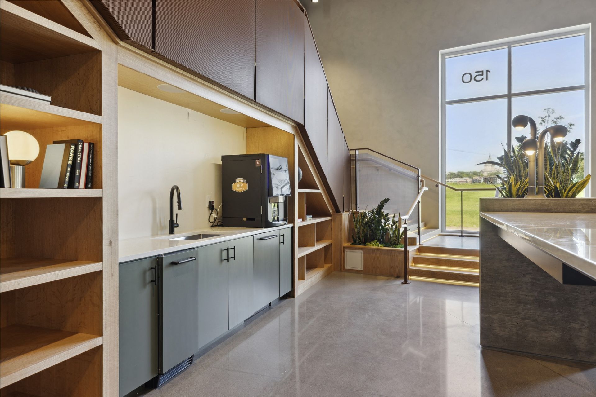 Modern communal kitchenette with sink, coffee machine, and built-in cabinets in a shared space at Esox House in St. Paul, MN.