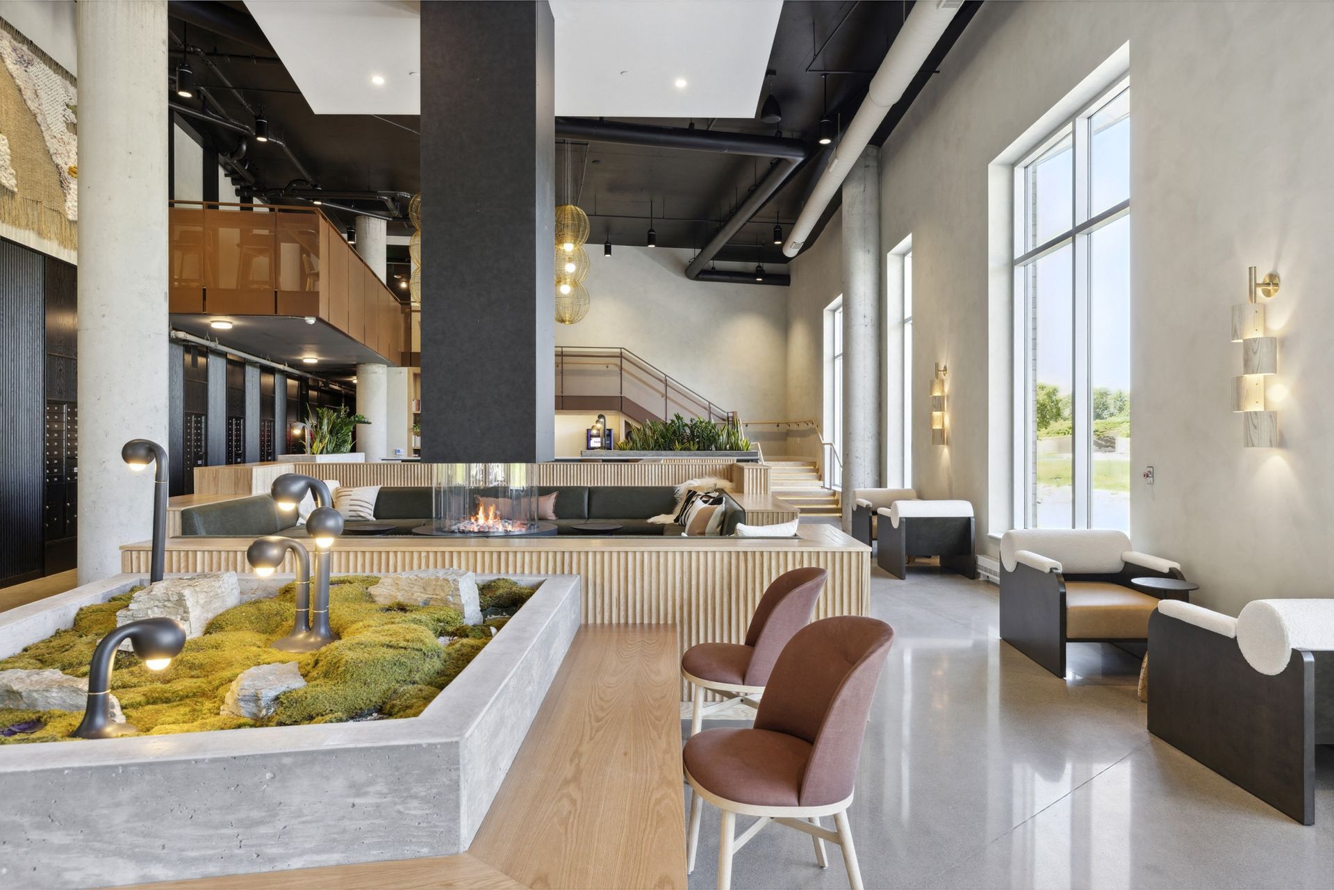 Modern apartment lobby with lounge seating, a fireplace, and large windows at Esox House in St. Paul, MN.