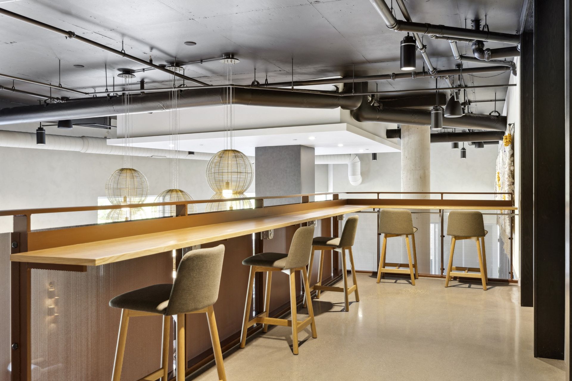 Interior communal lounge with a long bar-height wooden counter and stools at Esox House in St. Paul, MN.