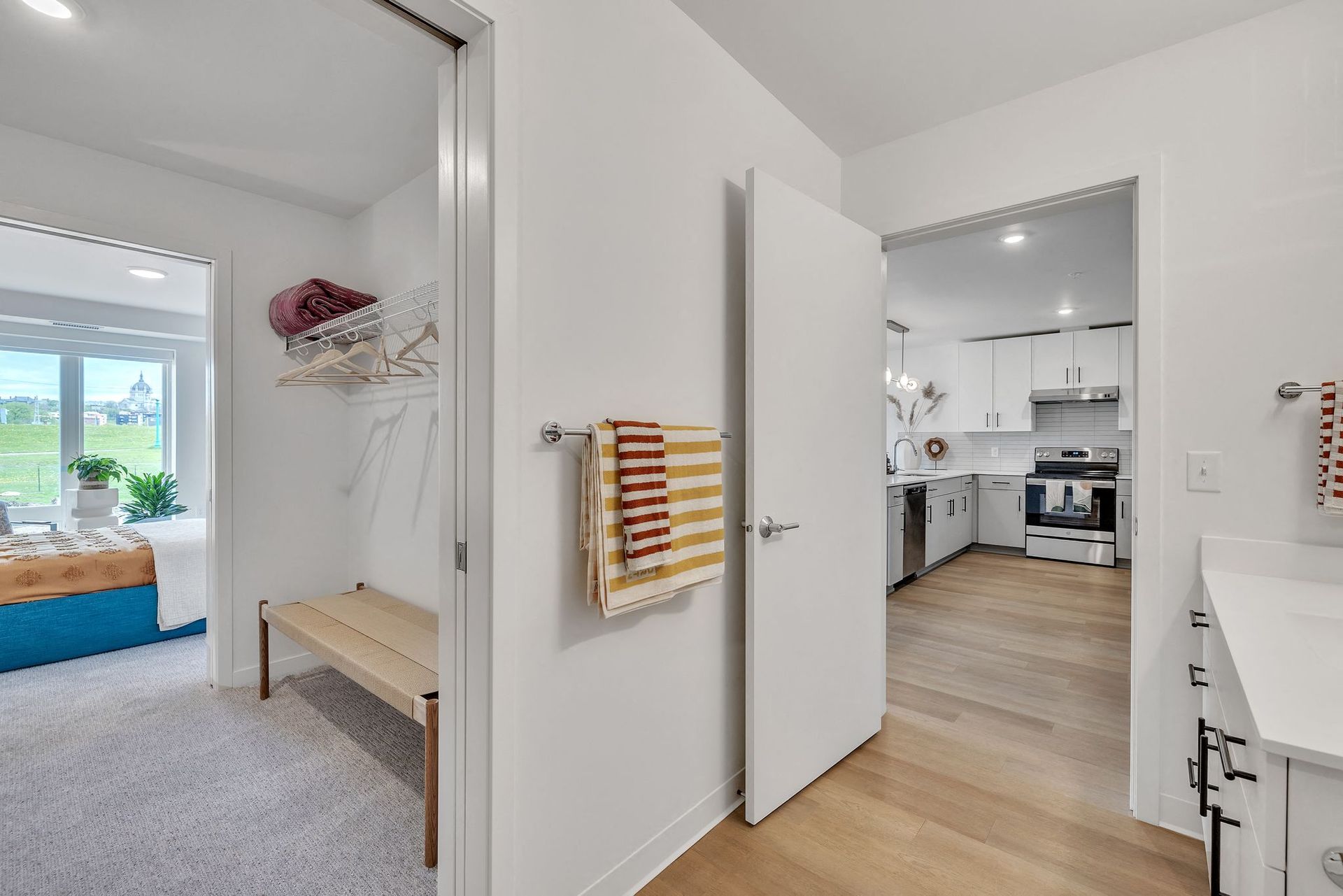Bright apartment interior: hallway leading to a modern kitchen and adjacent bedroom at Esox House in St. Paul, MN.